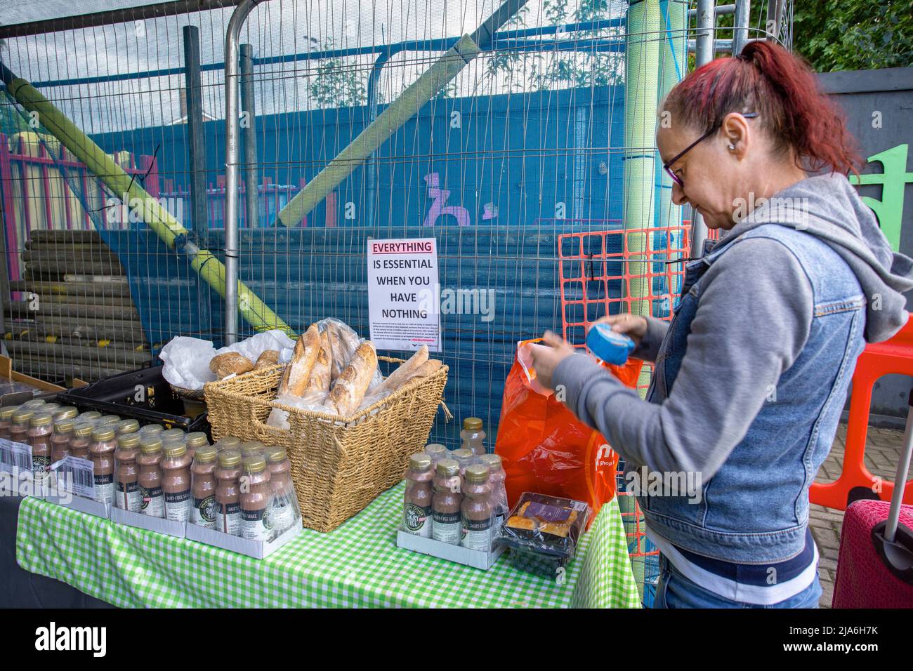 Donna che raccoglie cibo dalla banca alimentare locale nel sud-ovest di Londra, Inghilterra Foto Stock