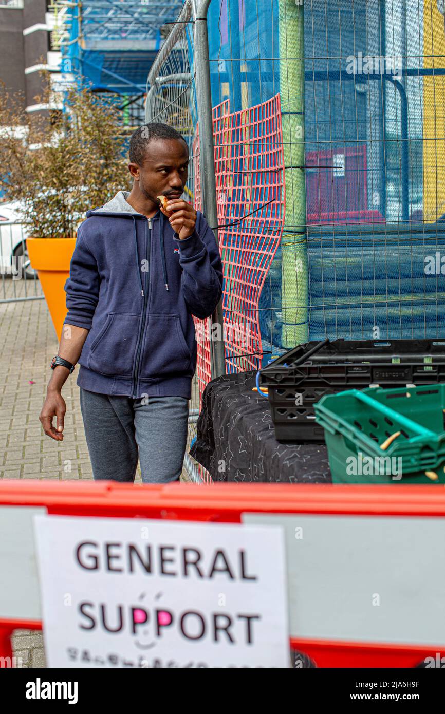 Gli uomini mangiano fuori da una banca di cibo per le persone che soffrono di difficoltà finanziarie al Lewisham Donation Hub, Londra , Inghilterra . Foto Stock