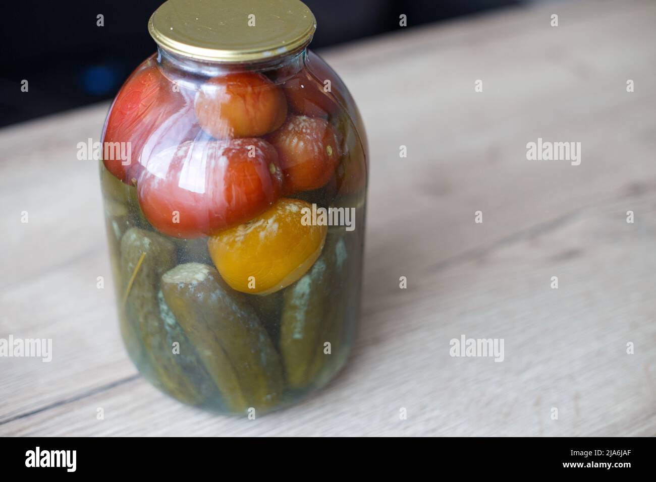 lattina viziata di aggraffatura vegetale. Vaso in vetro con pomodori e cetrioli fatti in casa sottaceto con funghi bianchi e muffa Foto Stock