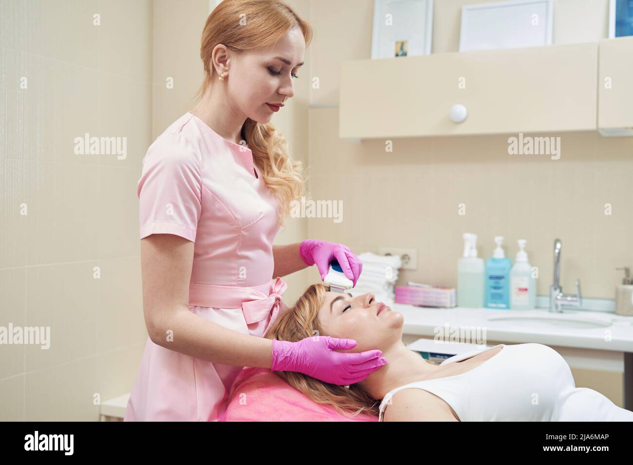 Dermatologo che effettua la pulizia del viso da puntini neri e altre impurità Foto Stock