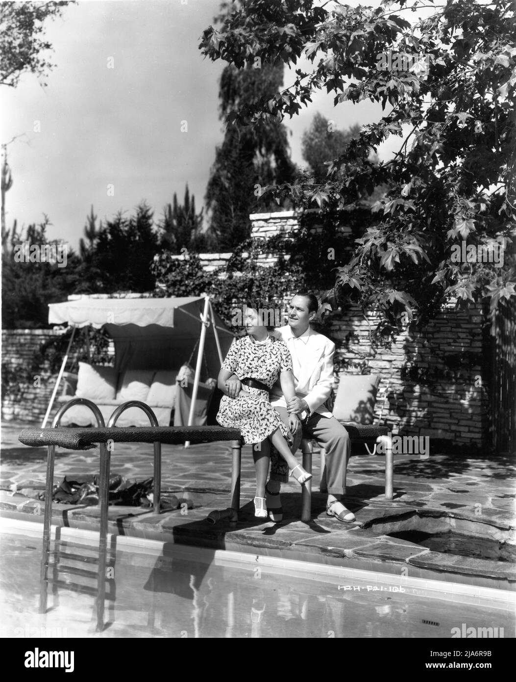 FREDRIC MARCH e la sua attrice moglie 2nd FLORENCE ELDRIDGE nel 1938 presso la piscina della loro casa di Hollywood al 1026 Ridgedale Road a Bel Air Los Angeles Pubblicità per Hal Roach Studios / United Artists Foto Stock