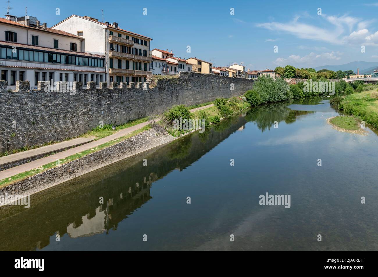 Il sentiero lungo il fiume Bisenzio nel centro storico di Prato, in una giornata di sole Foto Stock