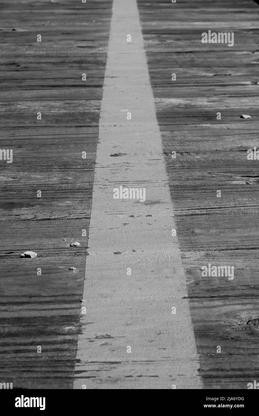 Primo piano di una linea luminosa dipinta sulla piattaforma in legno in bianco e nero. Foto Stock