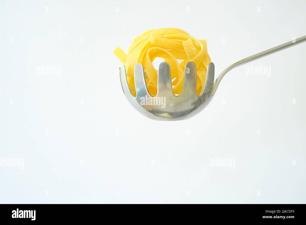 Tagliatelle di pasta italiana isolate su sfondo bianco Foto Stock