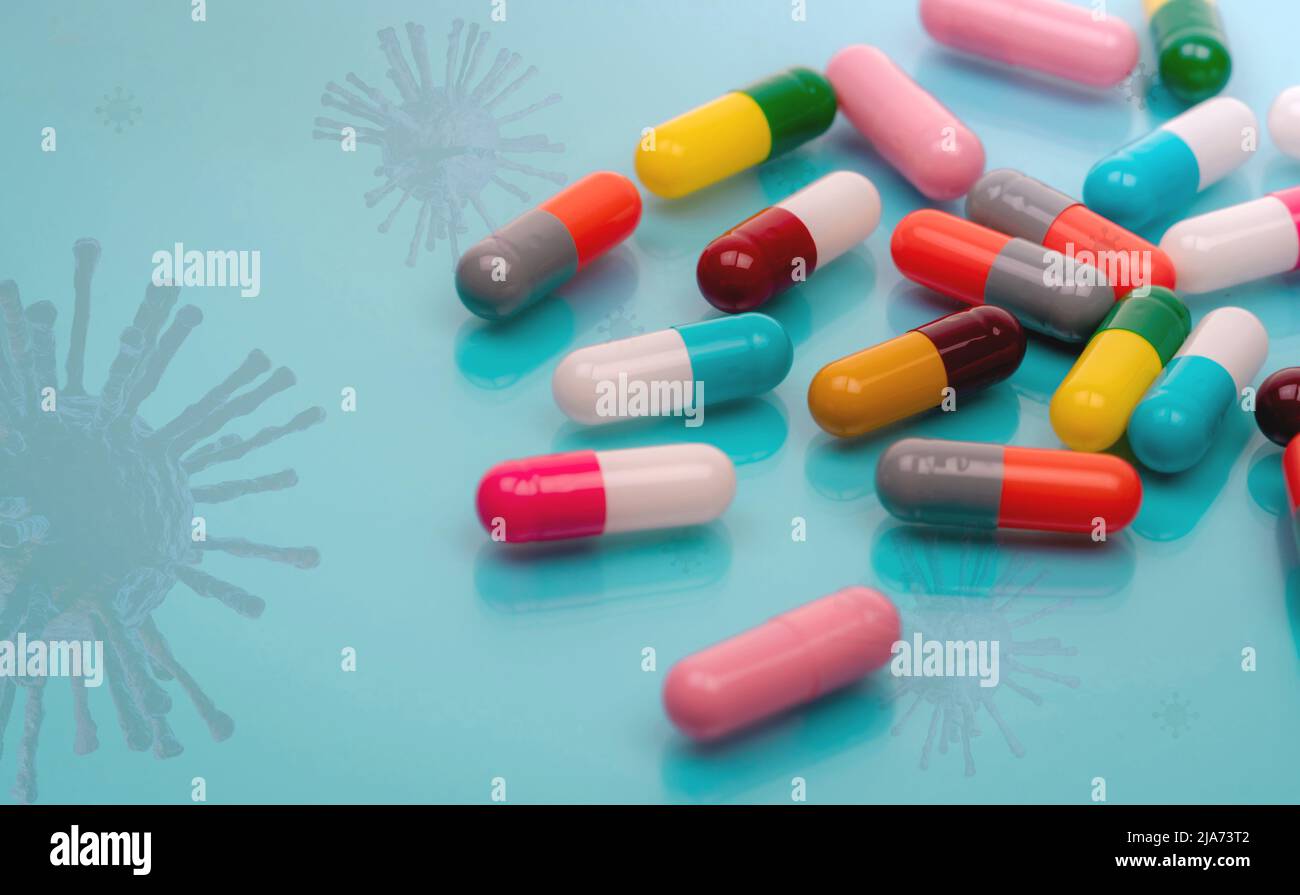 Capsule antivirali con virus su sfondo blu. Sviluppo di farmaci e ricerca di nuovi farmaci per il trattamento di malattie infettive emergenti. Prescrizione Foto Stock