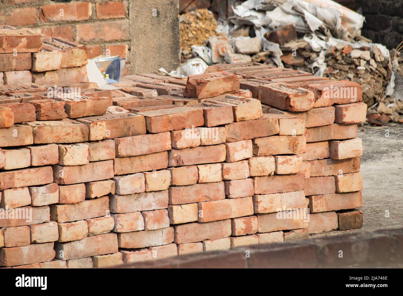Mattoni accatastati insieme per costruzione in area urbana indiana. Foto Stock