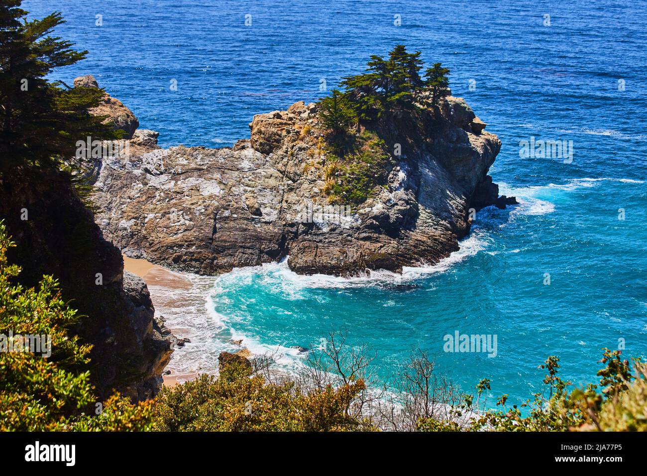 Baia sulla spiaggia con acque blu mozzafiato e scogliere rocciose Foto Stock