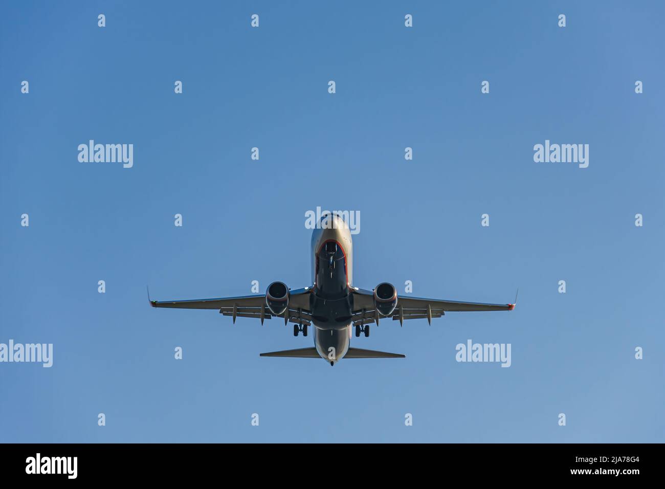 Aereo di linea passeggeri con carrello di atterraggio esteso, atterraggio all'aeroporto, vista dal basso Foto Stock