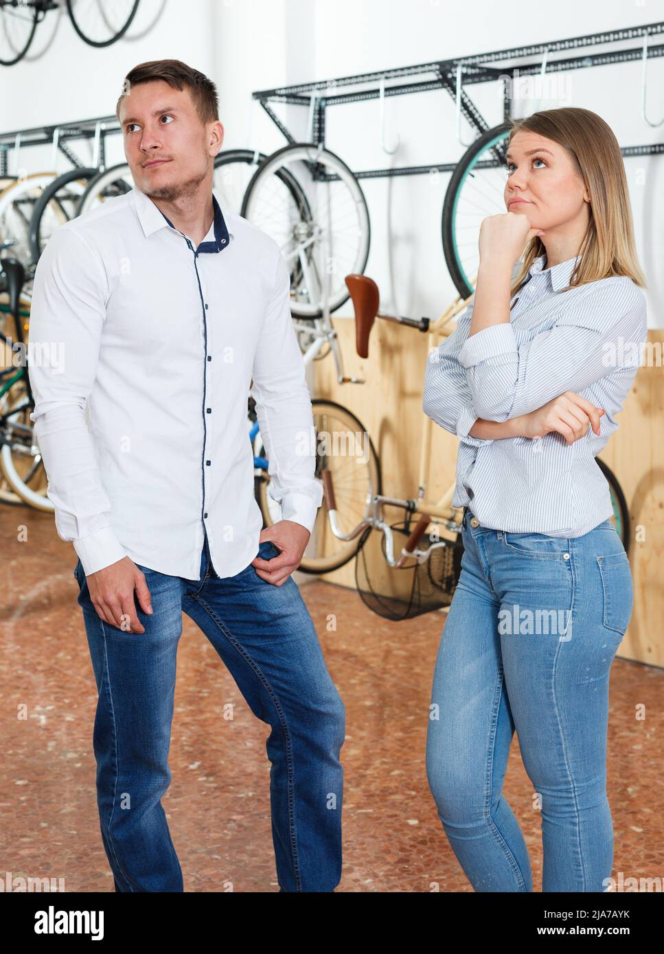 La coppia sta facendo shopping e scegliendo la nuova bicicletta ed avendo disaccordi Foto Stock