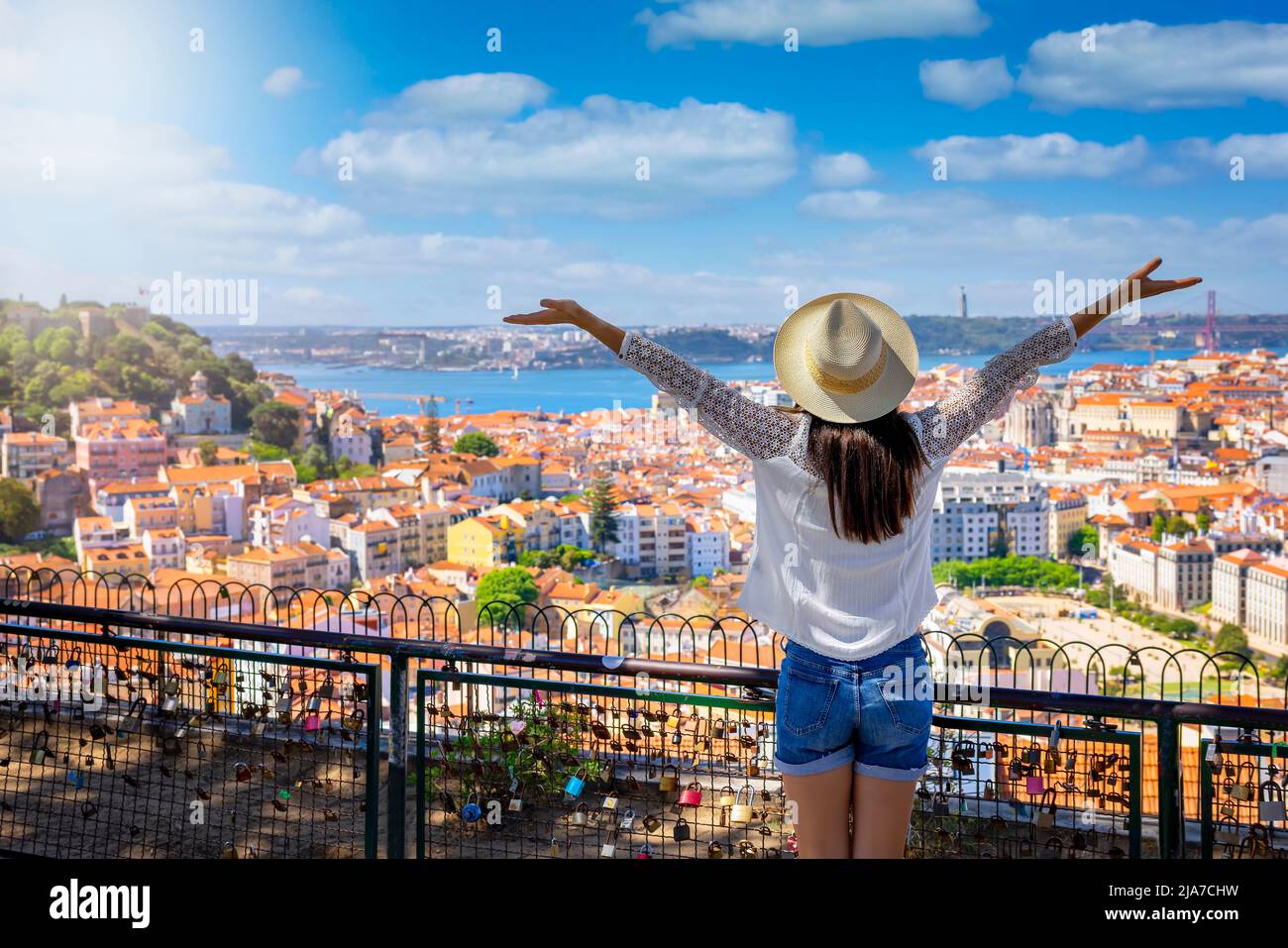 Una donna turistica felice si affaccia sul colorato centro storico di Alfama della città di Lisbona Foto Stock
