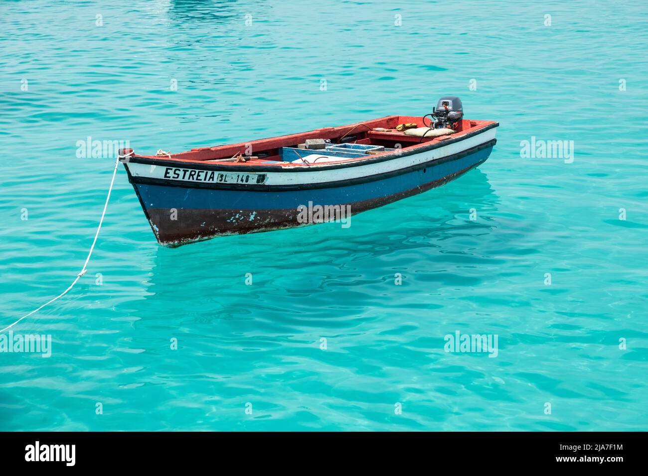 Barca da pesca in legno rosso, bianco e blu sulle acque turchesi dell'Atlantico a Santa Maria, SAL, Isola di Capo Verde, Isole di Cabo Verde, Africa Foto Stock