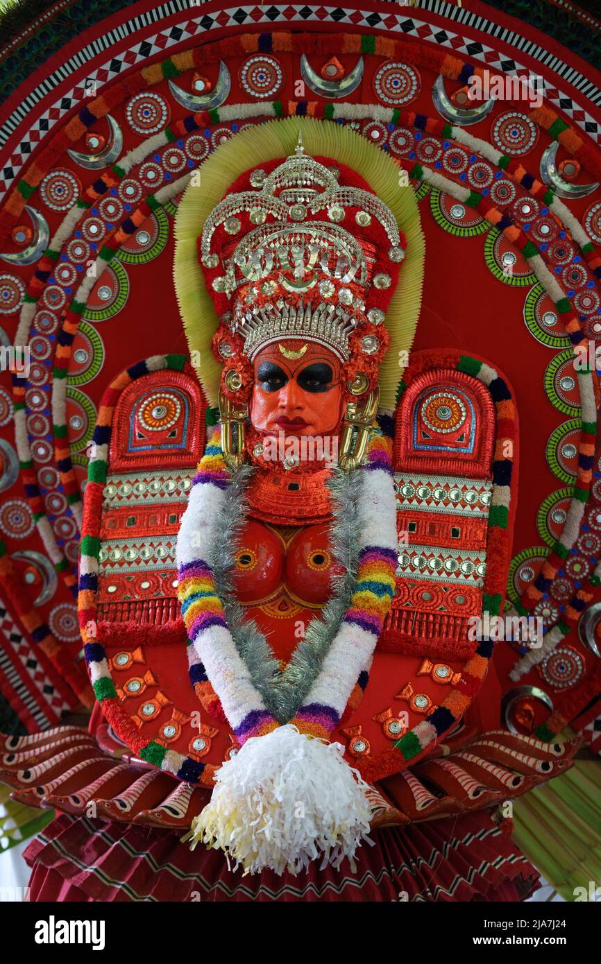 Theyyam è una famosa forma d'arte rituale in kerala con il volto dipinto utilizzando colori organici e l'uso di strumenti musicali come Chenda, Elathalam, Kurumkuzal Foto Stock