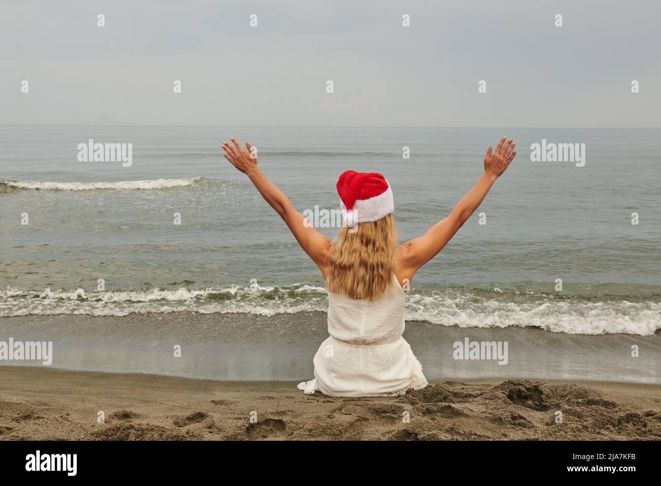 cappello rosso bianco vestire le mani ai lati alla demo al mare Foto Stock