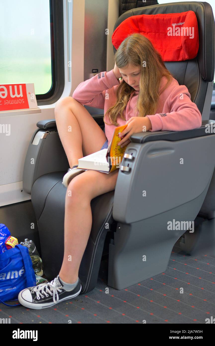 Una adolescente donna che viaggia da sola in treno (classe prima oeb), Austria AT Foto Stock