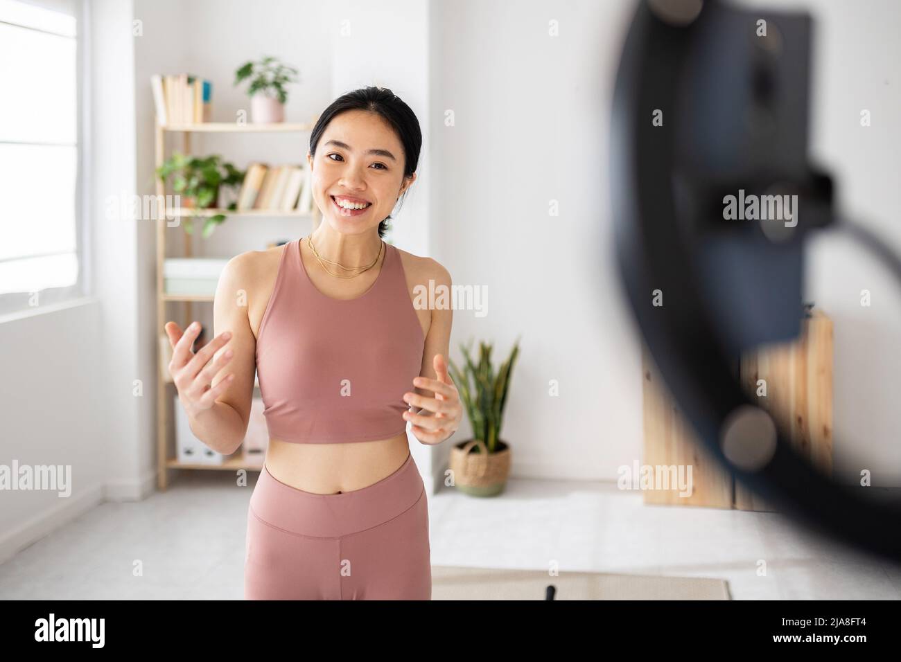 Fitness giovane donna asiatica che registra online classe a casa Foto Stock