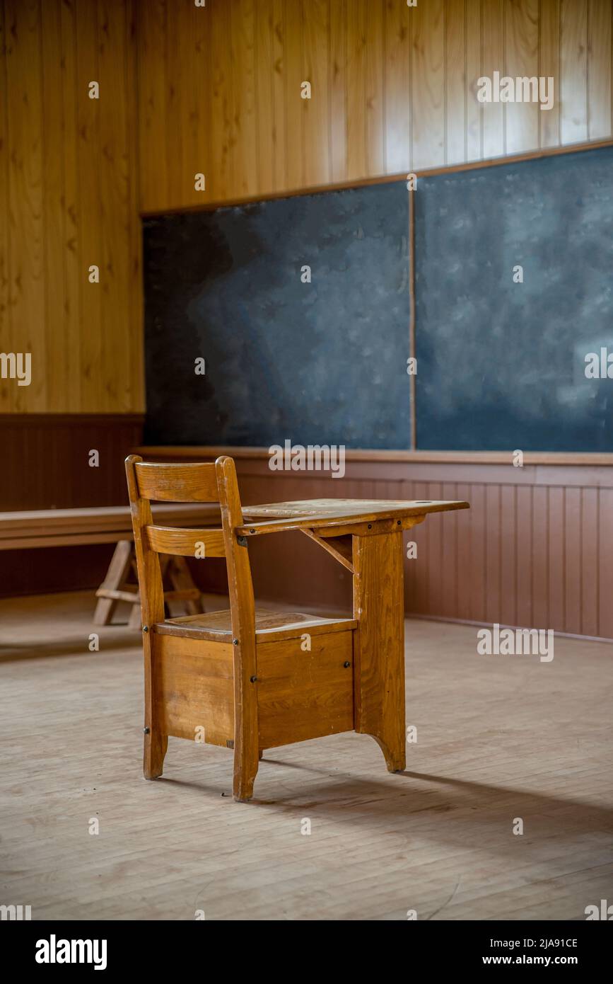 Una scrivania singola in legno in una scuola rurale abbandonata a una stanza sulle praterie di Saskatchewan Foto Stock