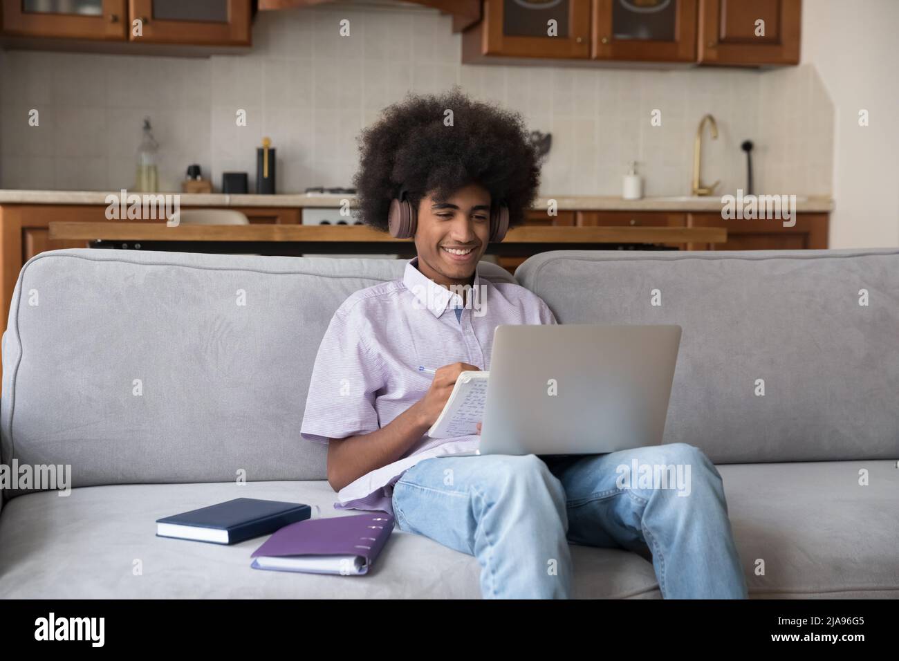 Felice ragazzo studente della scuola superiore nero allegro in grandi cuffie Foto Stock