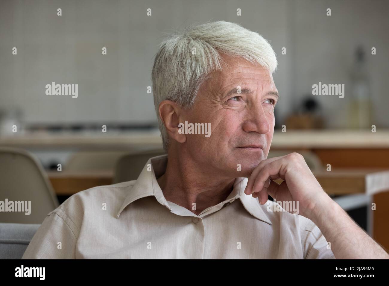 Il nonno pensieroso di età più anziana si siede sul divano guardare lontano Foto Stock