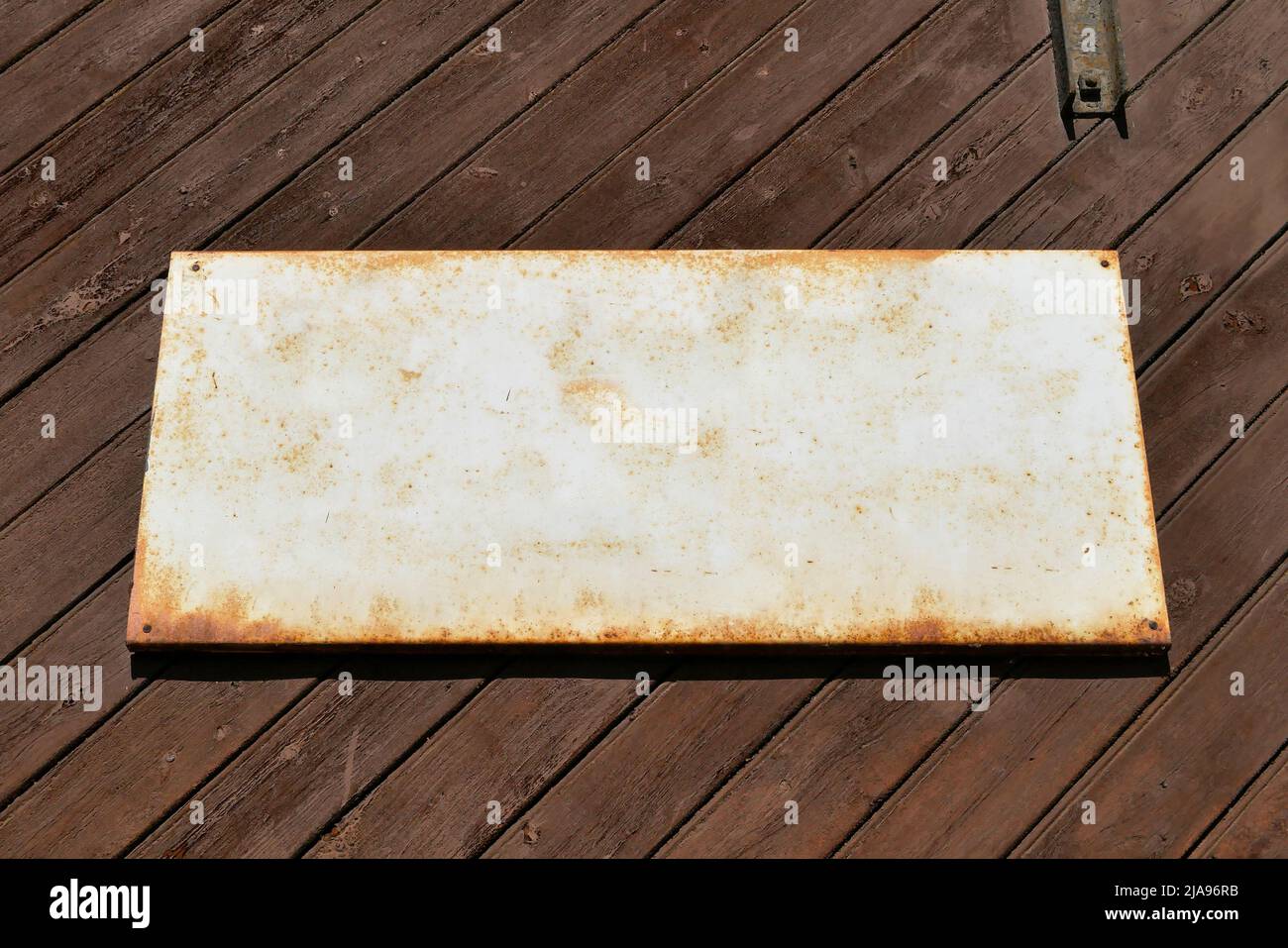 Vecchio cartello di stagno per modello di testo su un vecchio muro di legno. Foto Stock