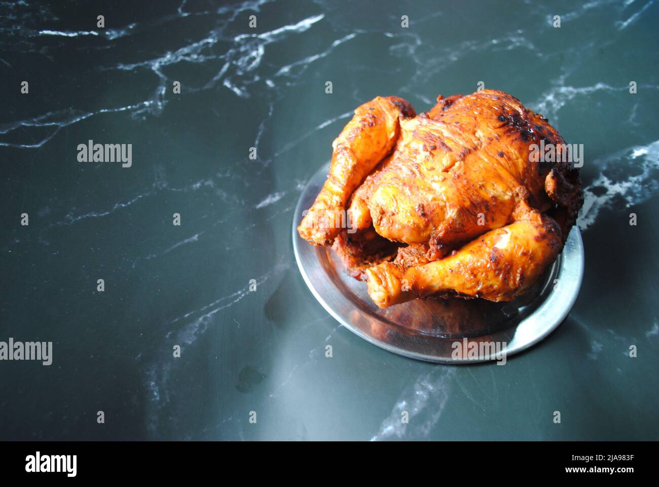 Il pollo piccante Juicy Grill dell'Empire Restaurant è collocato su un piatto d'argento e pronto a gustare Foto Stock