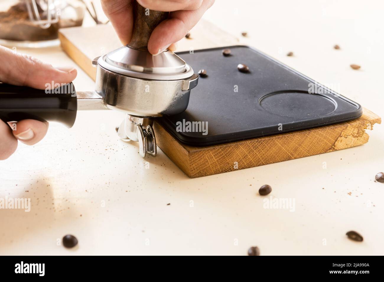 Il barista utilizza un manomissione per preparare il caffè. Foto Stock