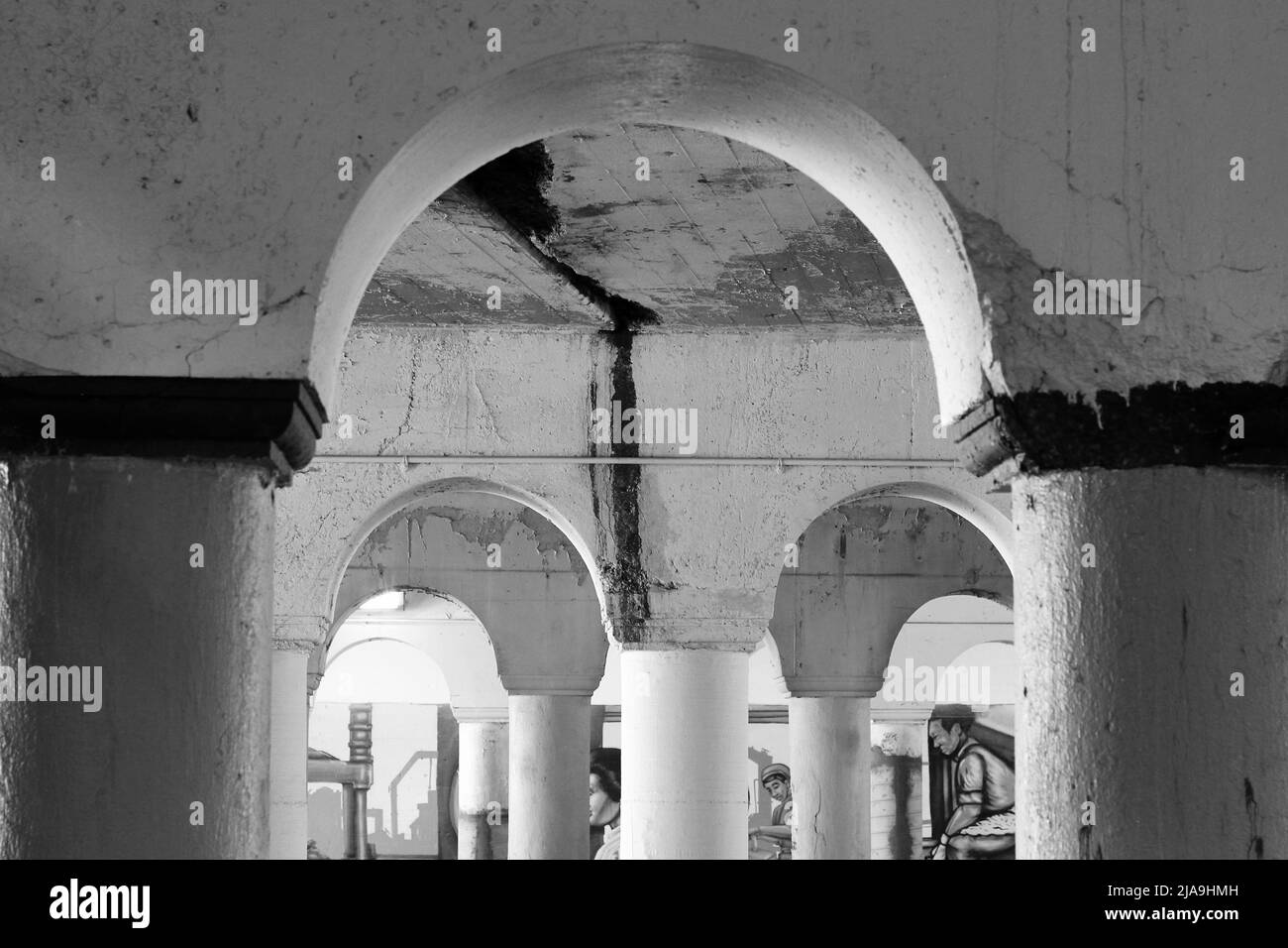 Colonnato industriale della città interna di colonne in cemento che reggono un ponte in bianco e nero. Foto Stock