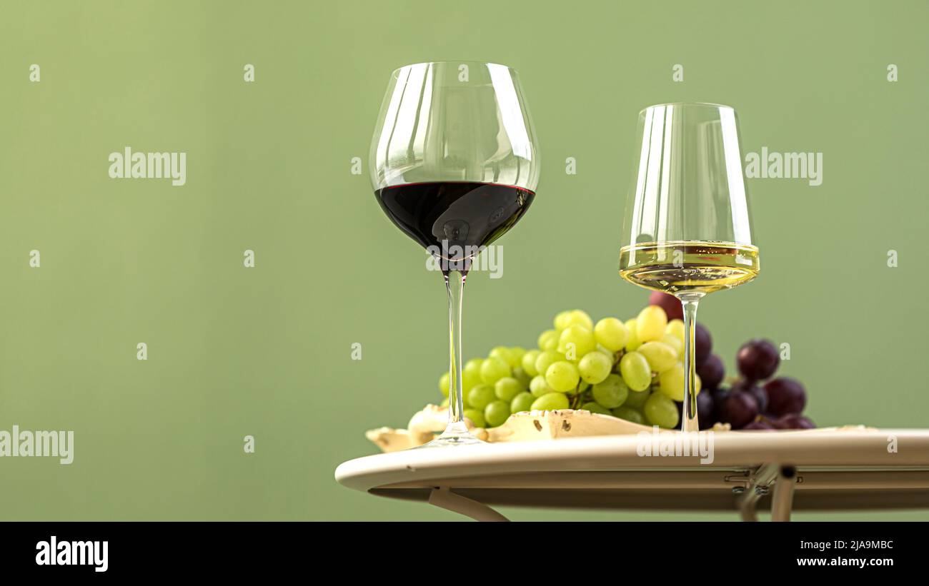 Bicchieri di vino bianco e rosso con uva Foto Stock