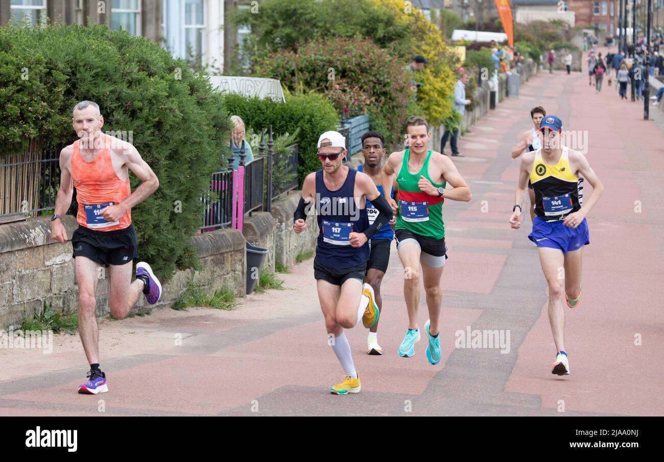 Portobello Promenade, Edimburgo, Scozia, Regno Unito 29th maggio 2022. I corridori del Festival della maratona di Edimburgo parteranno alle 10am. Nella foto i corridori anteriori uscendo dall'estremità orientale del lungomare, il vincitore Matthew Gilette in giallo e nero a destra della foto, Time 2.17.57. Foto Stock