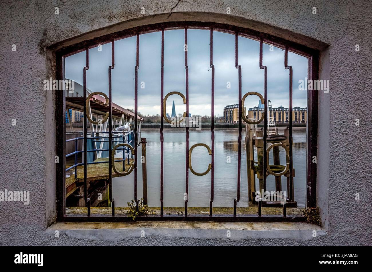 Vista sul Tamigi dal Molo dell'India occidentale sul Tamigi Path, lo Shard in lontananza. Foto Stock
