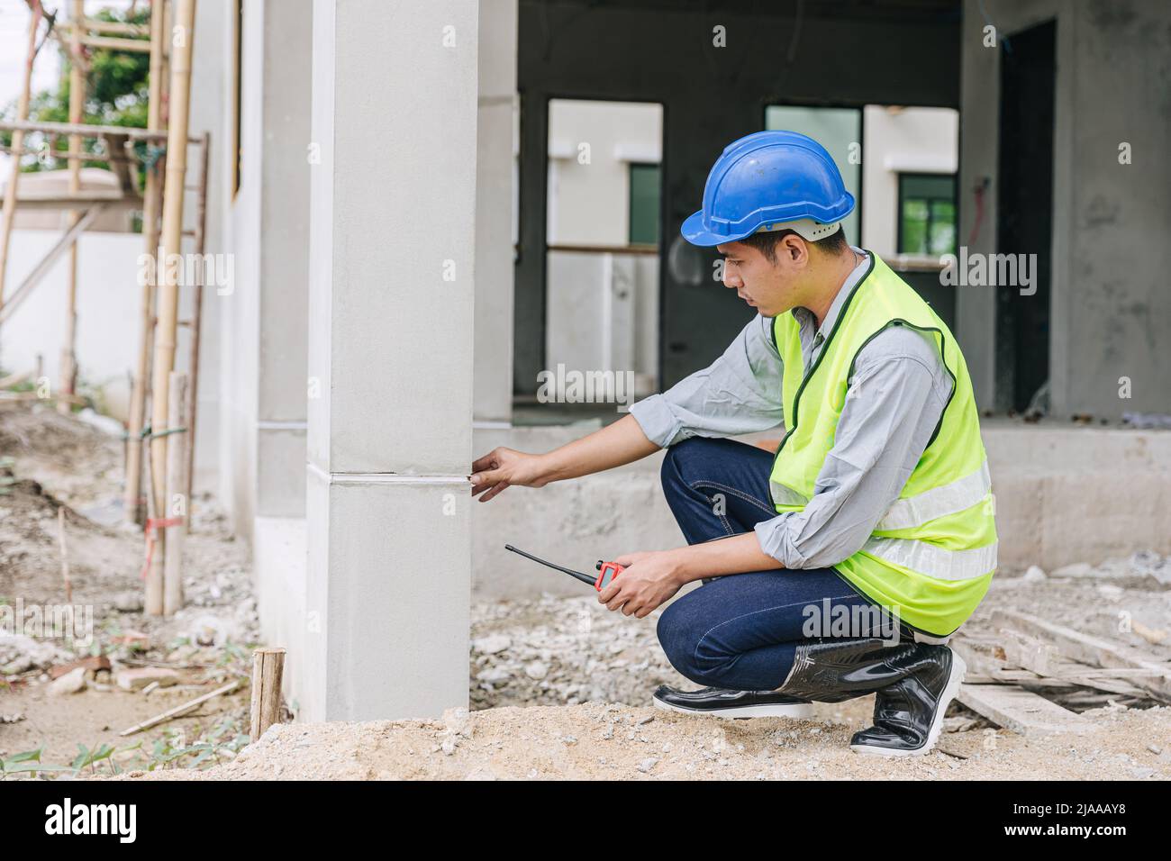 ingegnere capo lavoro controllo dettaglio di costruzione casa pilastri costruire qualità in cantiere Foto Stock