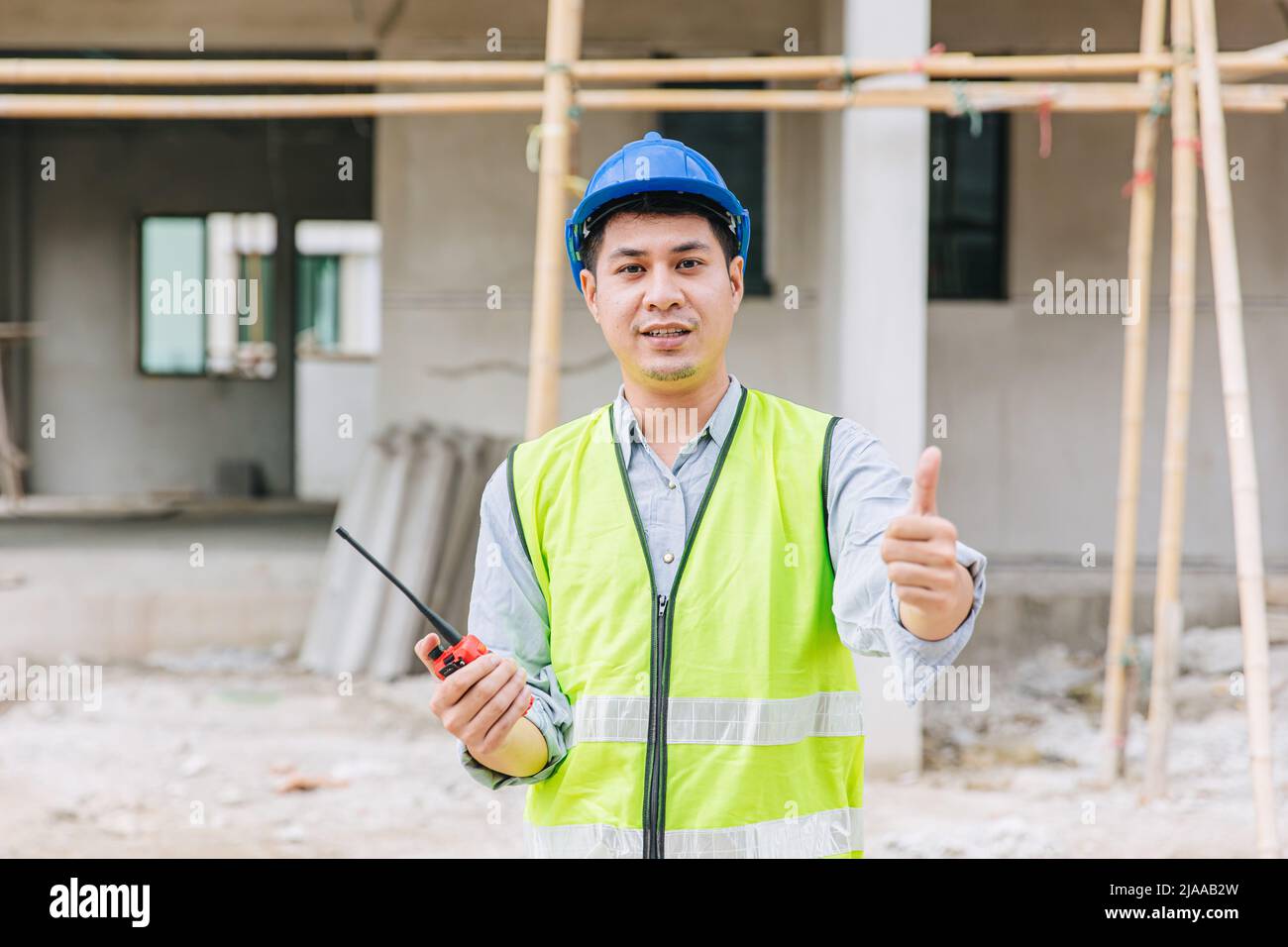 lavoratore casa casa costruttore foreman segno pollici in su per il buon passo costruire e la qualità di sicurezza confermare concetto. Foto Stock