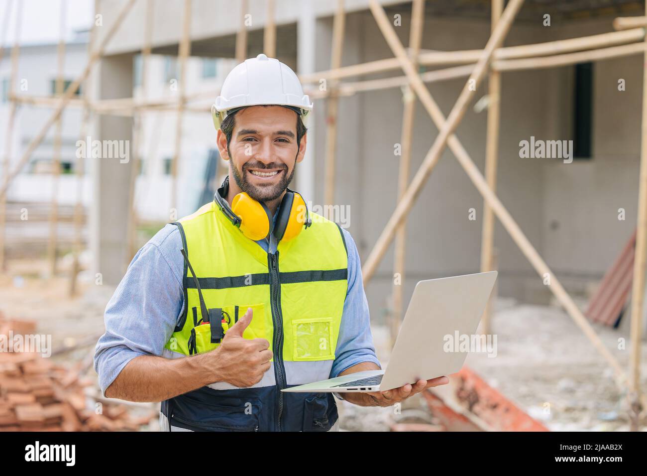 caucasico latino lavoratore uomo casa costruttore mano segno pollici in su per il buon passo costruire e la qualità di sicurezza confermare concetto. Foto Stock