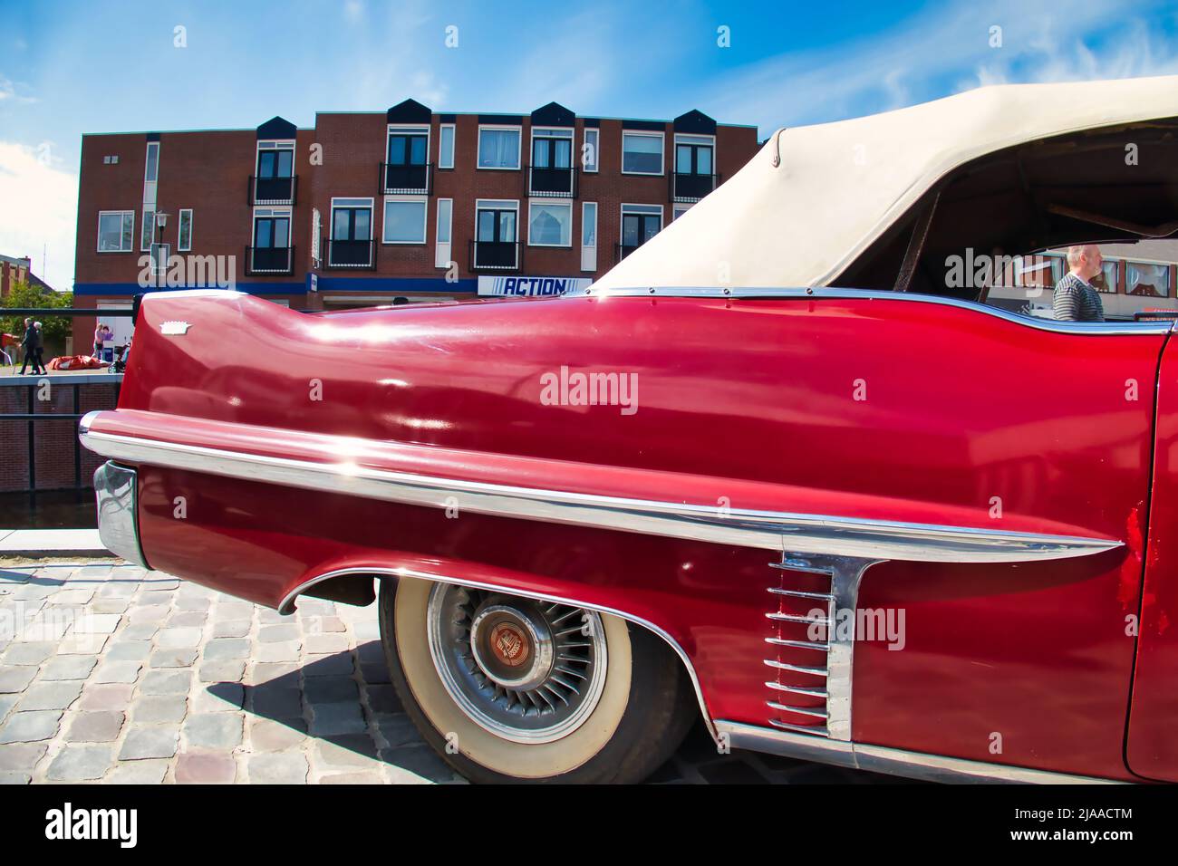 Parte posteriore e pinna di coda con una cromatura di un'auto d'epoca rossa Cadillac coupé deville convertibile anni '50 in una mostra d'auto classica a Uithuizen, Paesi Bassi Foto Stock