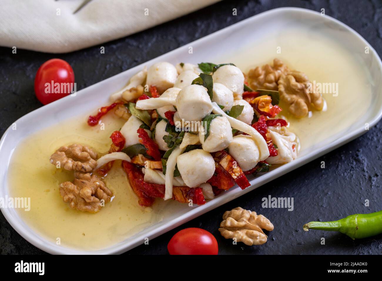 Formaggio per la colazione preparato appositamente. Uno speciale piatto di formaggi preparato con olio d'oliva, verdure, noci e formaggi. Primo piano Foto Stock