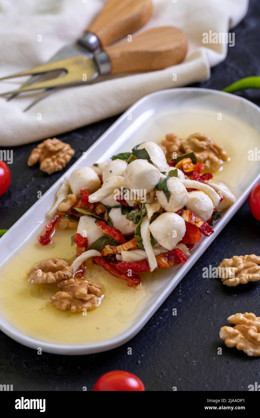 Formaggio per la colazione preparato appositamente. Uno speciale piatto di formaggi preparato con olio d'oliva, verdure, noci e formaggi. Primo piano Foto Stock