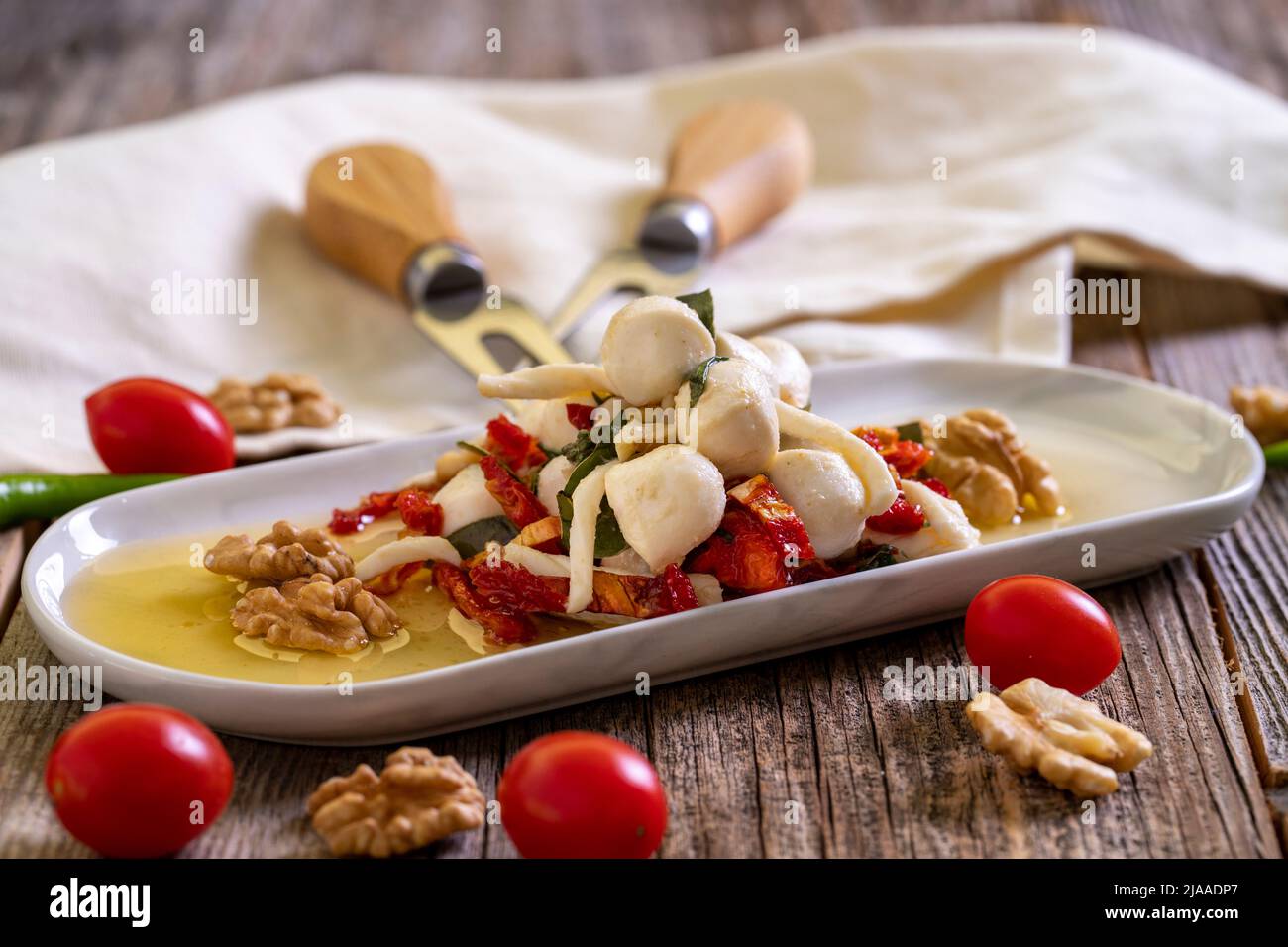 Formaggio per la colazione preparato appositamente. Uno speciale piatto di formaggi preparato con olio d'oliva, verdure, noci e formaggi. Primo piano Foto Stock
