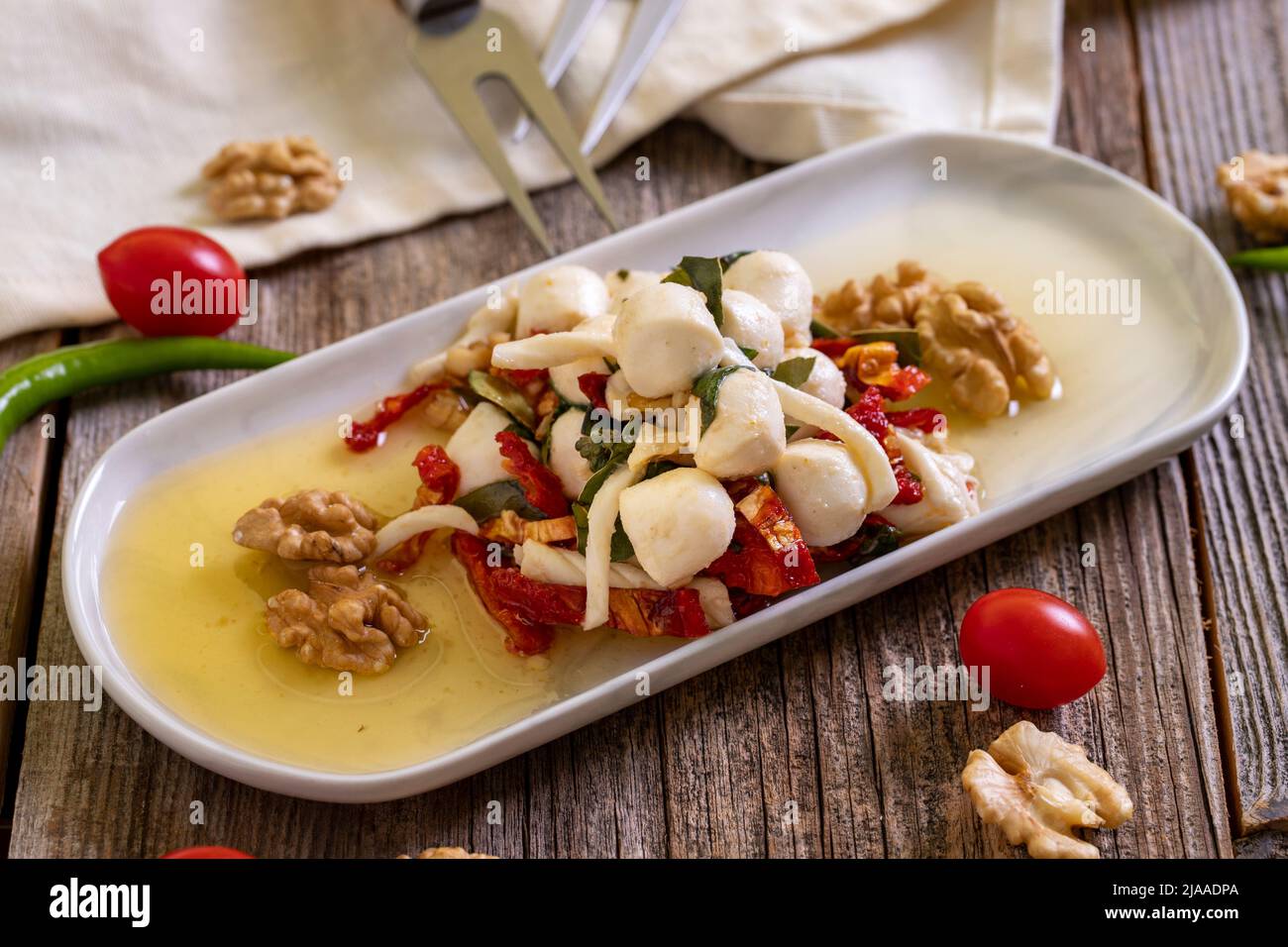 Formaggio per la colazione preparato appositamente. Uno speciale piatto di formaggi preparato con olio d'oliva, verdure, noci e formaggi. Primo piano Foto Stock