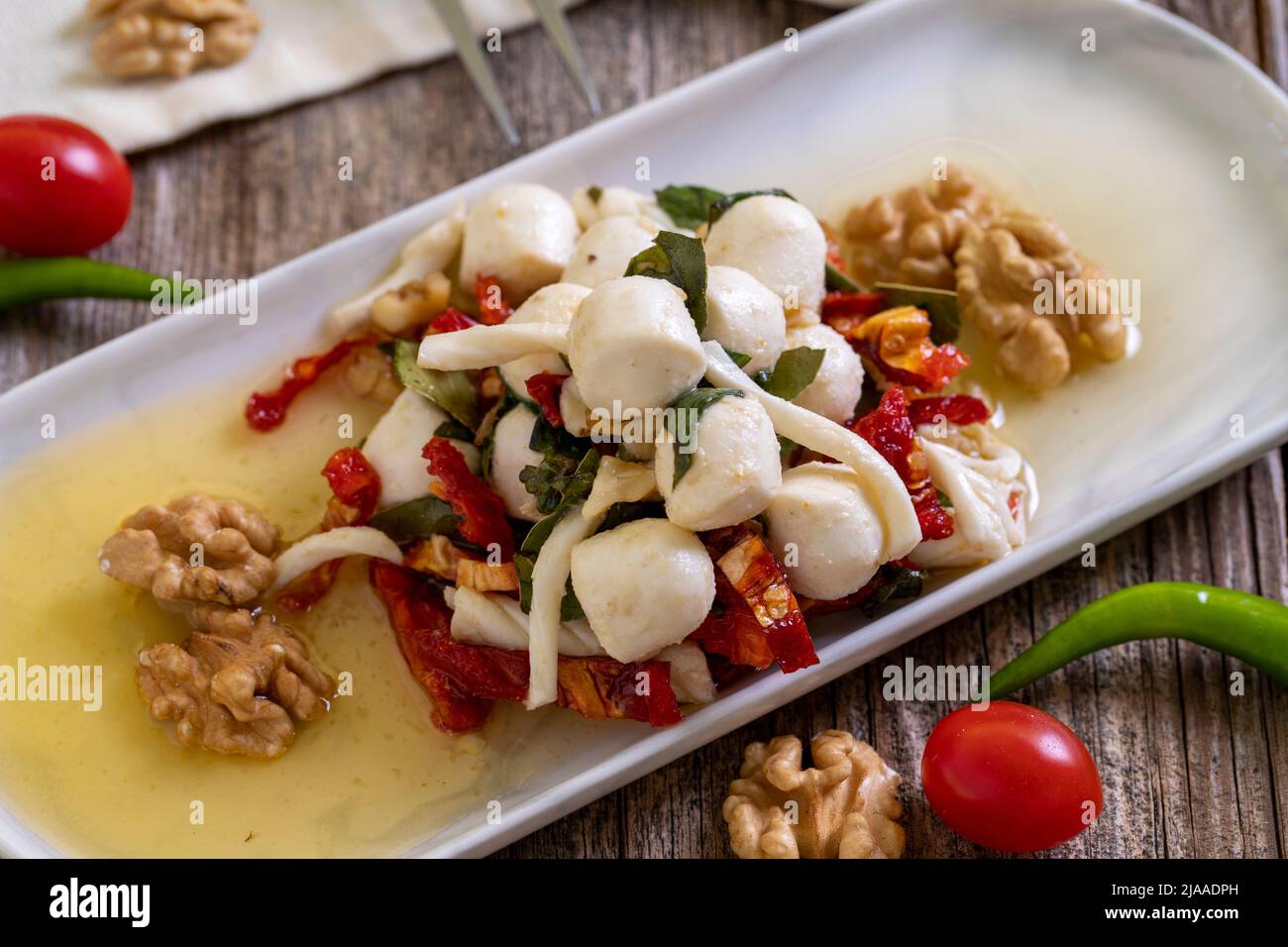 Formaggio per la colazione preparato appositamente. Uno speciale piatto di formaggi preparato con olio d'oliva, verdure, noci e formaggi. Primo piano Foto Stock