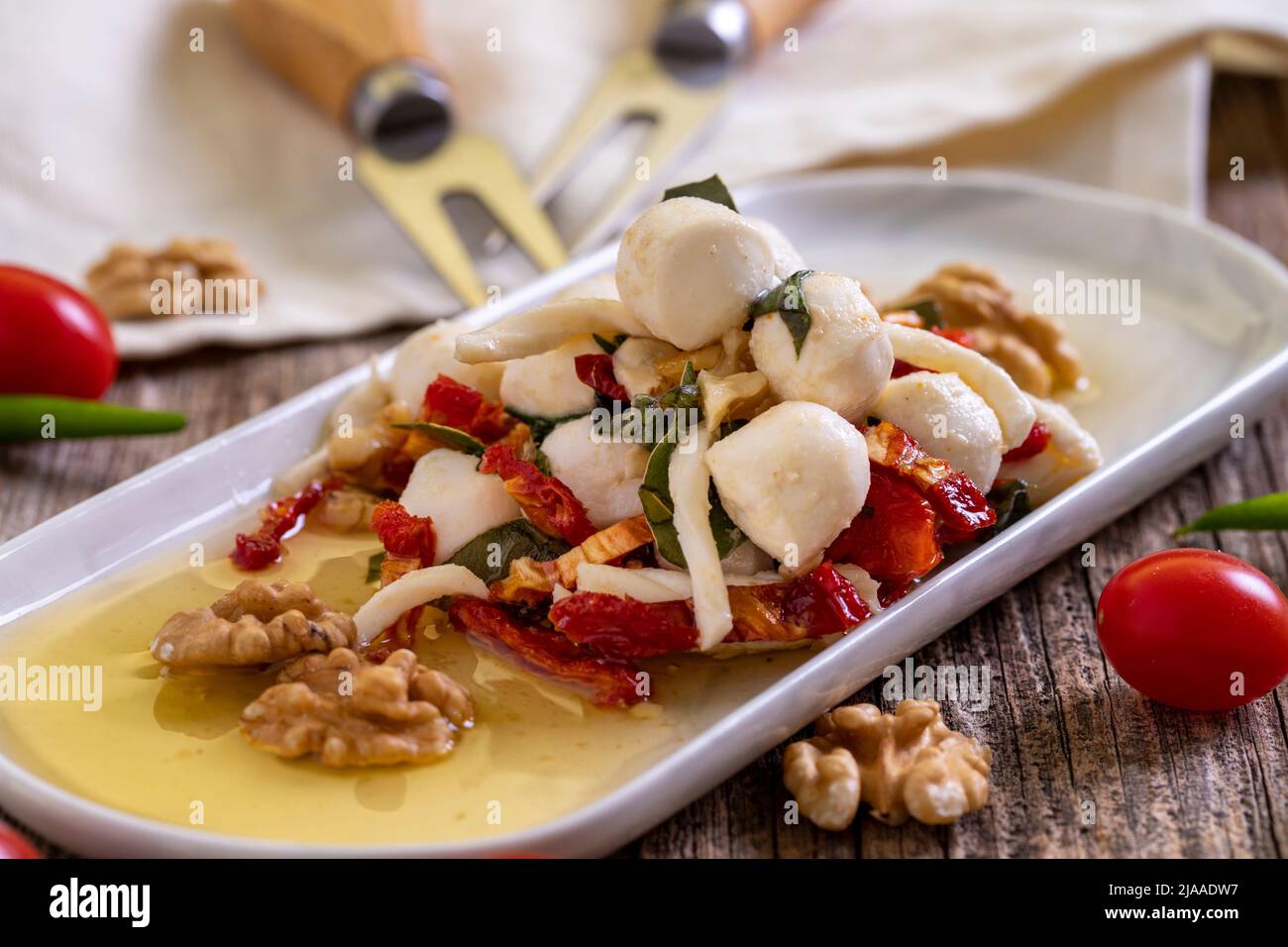 Formaggio per la colazione preparato appositamente. Uno speciale piatto di formaggi preparato con olio d'oliva, verdure, noci e formaggi. Primo piano Foto Stock