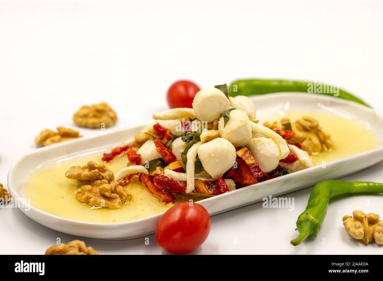 Formaggio per la colazione preparato appositamente. Uno speciale piatto di formaggi preparato con olio d'oliva, verdure, noci e formaggi. Primo piano Foto Stock