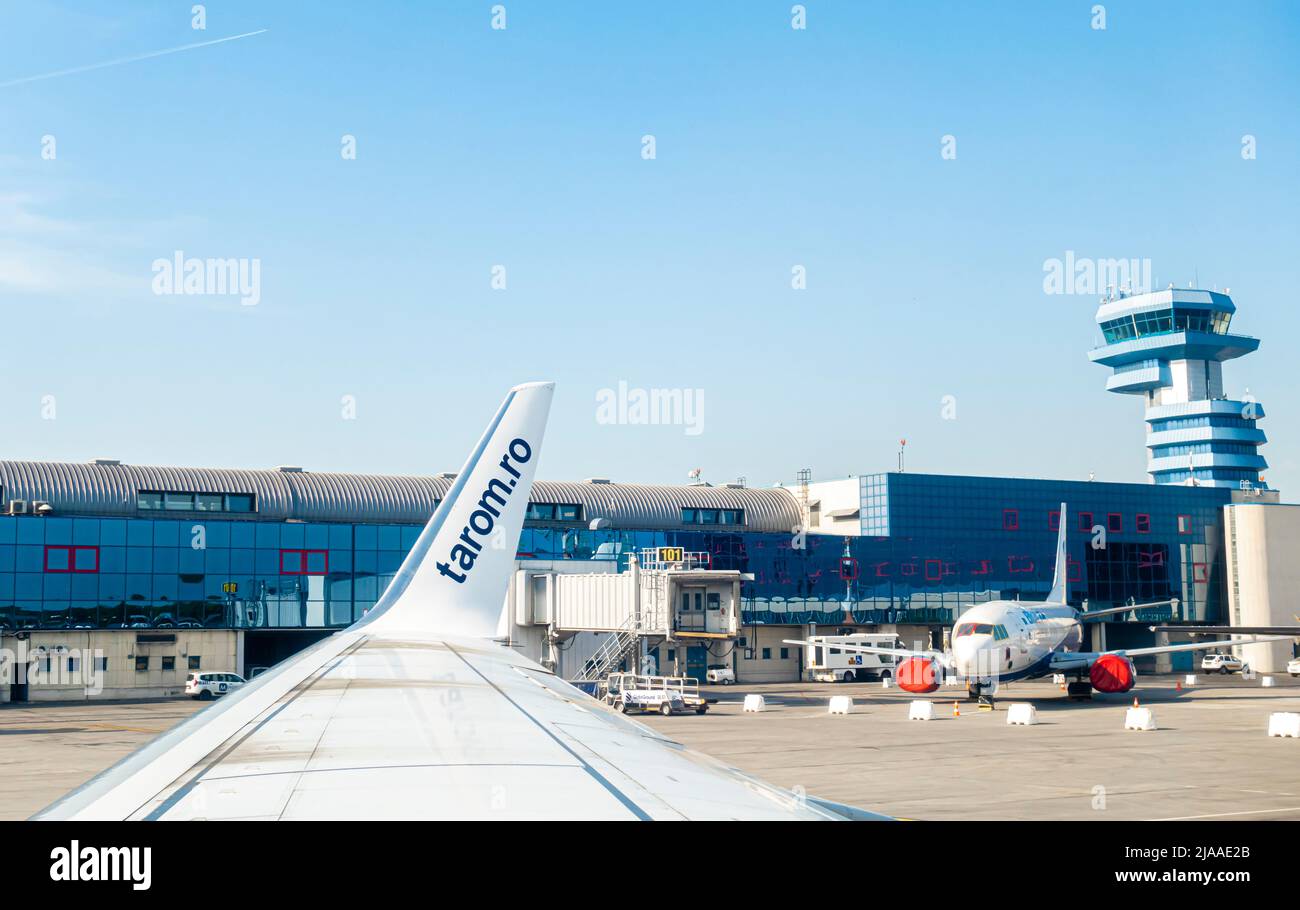 Henri Coandă International Airport building, OTP, Otopeni, Romania con e torre di controllo, aerei al cancello Vista dalla finestra aereo Tarom sul lato ala Foto Stock