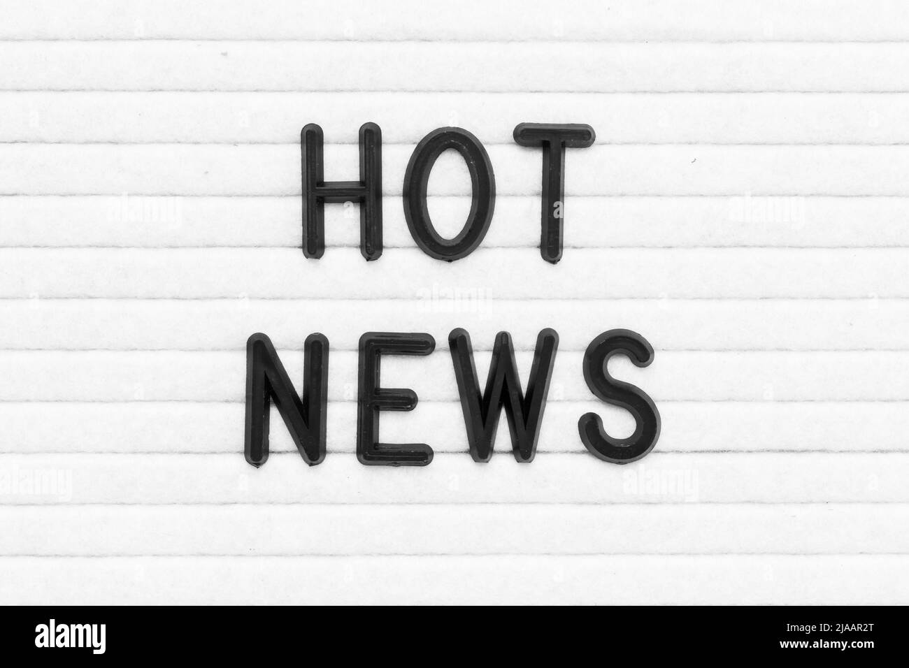 Lettera di colore nero in parola notizie calde sullo sfondo bianco del bordo del feltro Foto Stock