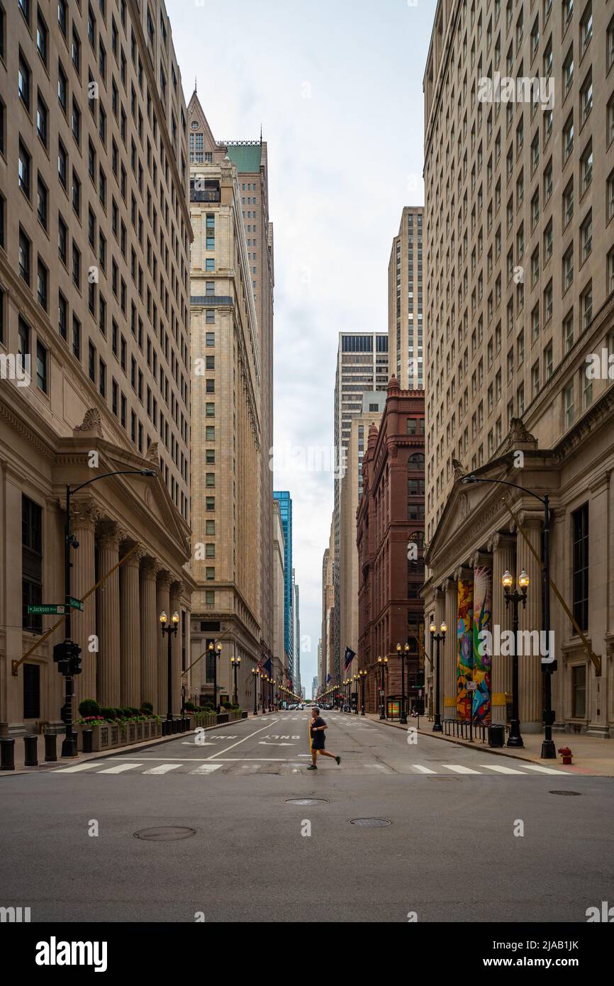 S la Salle Street, all'incrocio tra W Jackson Boulevard, Chicago, Illinois. Un uomo attraversa il crosswalk tra uno sfondo di edifici alti. USA Foto Stock