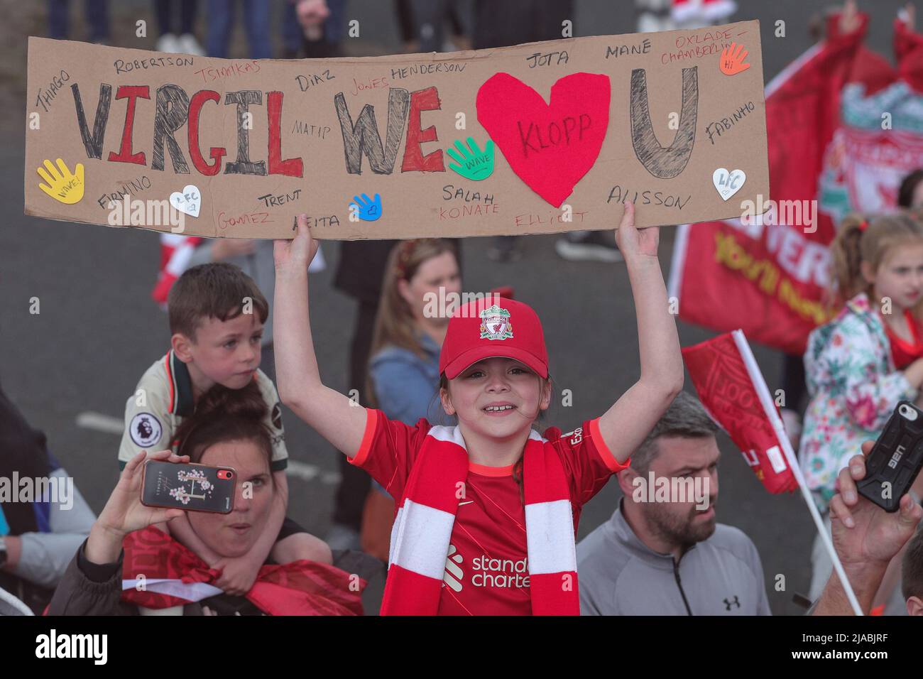 Un giovane sostenitore di Liverpool sostiene un banner ‘Virgil We Love You’ mentre la squadra del Liverpool FC festeggia durante la sfilata di autobus scoperto attraverso la città dopo aver vinto sia la Carabao Cup che la fa Cup nella stagione 2021/22 Foto Stock
