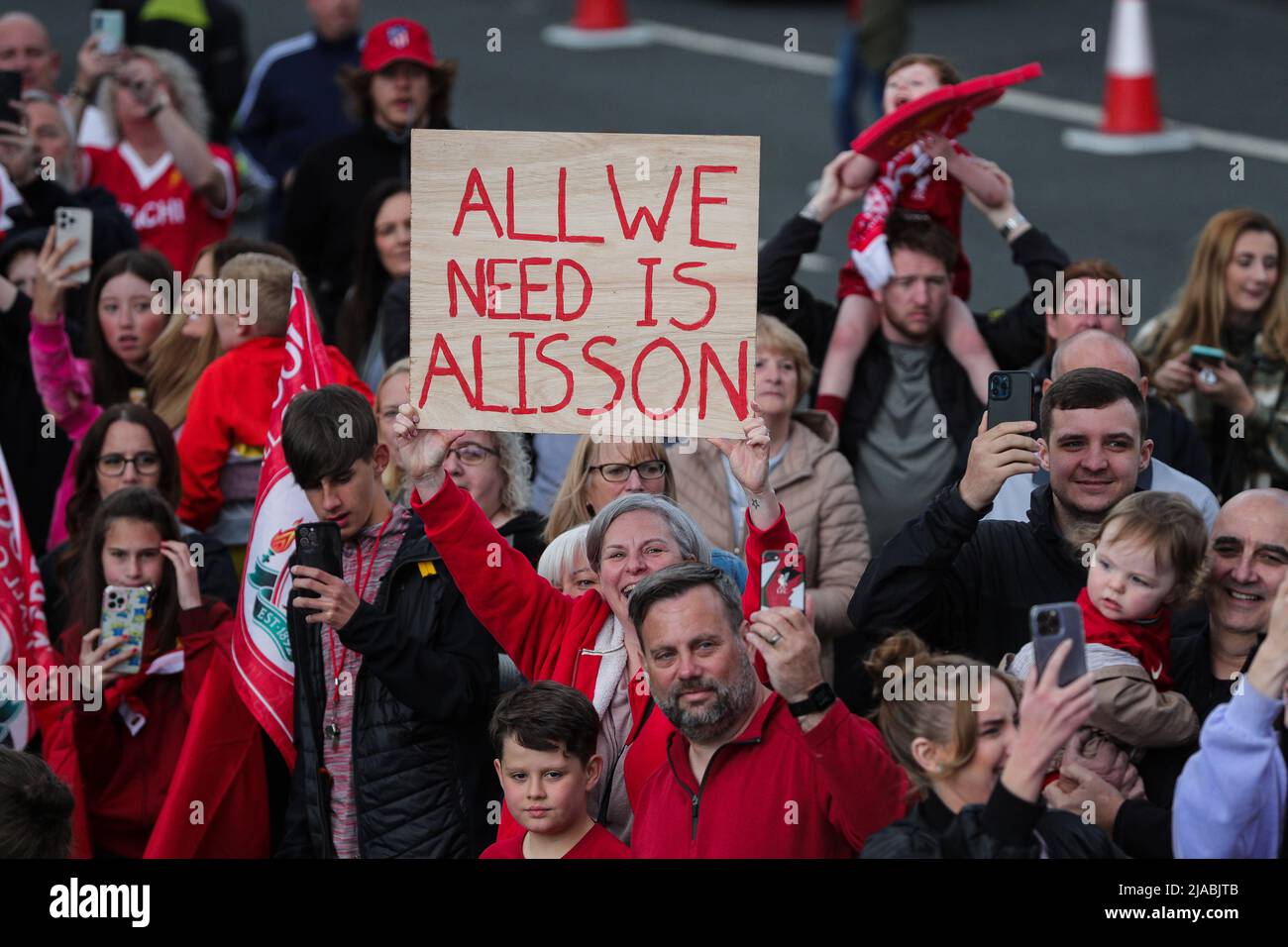 Un sostenitore di Liverpool sostiene un banner ‘All We Need is Alisson’ mentre la squadra del Liverpool FC festeggia durante la sfilata di autobus scoperto attraverso la città dopo aver vinto sia la Carabao Cup che la fa Cup nella stagione 2021/22 Foto Stock