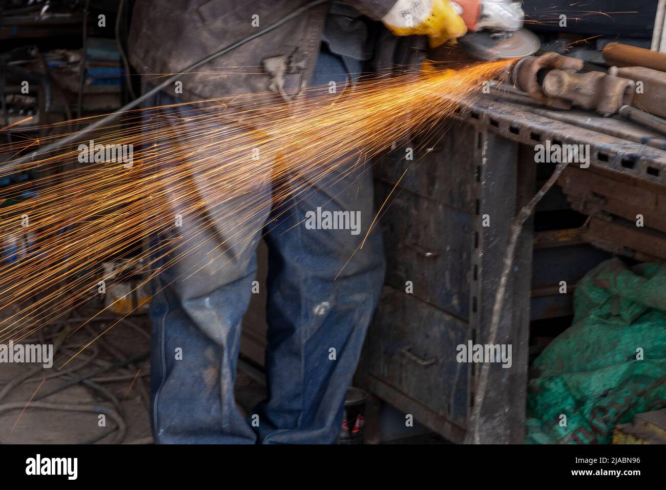 Lavoratore il taglio di metallo con la fresa. La formazione di scintille durante la macinazione di ferro Foto Stock