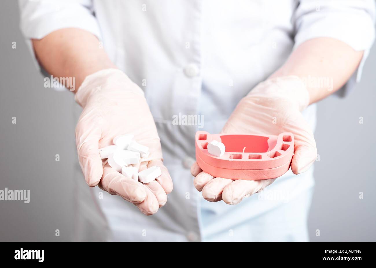 Dentista che mostra il modello della mandibola con dente singolo e denti caduti in mano al paziente. Implicazioni di cattiva cura orale, malattie dentali. Concetto di stomatologia. Foto di alta qualità Foto Stock