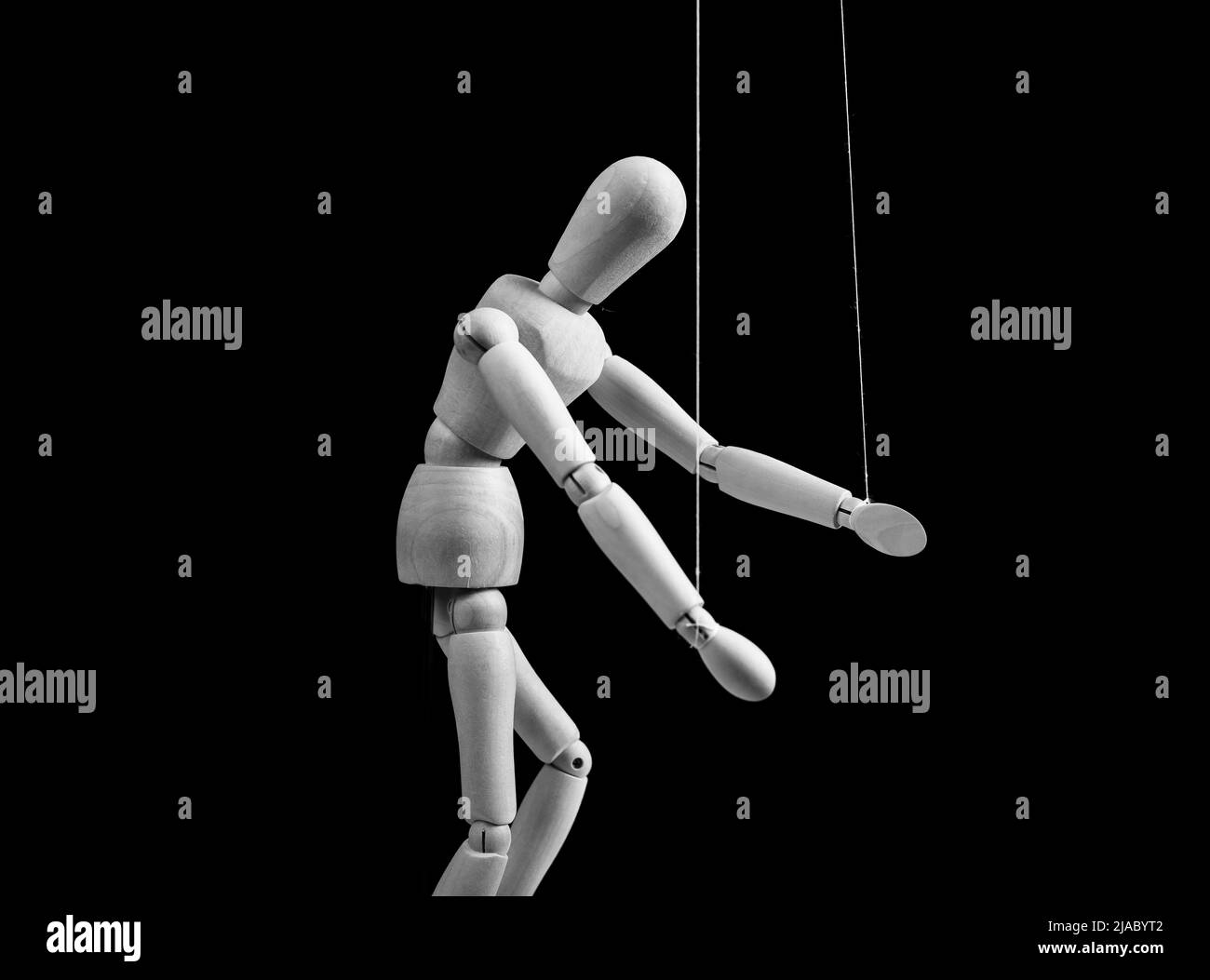 Marionetta su corde. Schiavitù, violenza, influenza negativa, concetto di dipendenza. Marionette in mano umana. Bianco e nero. Foto di alta qualità Foto Stock