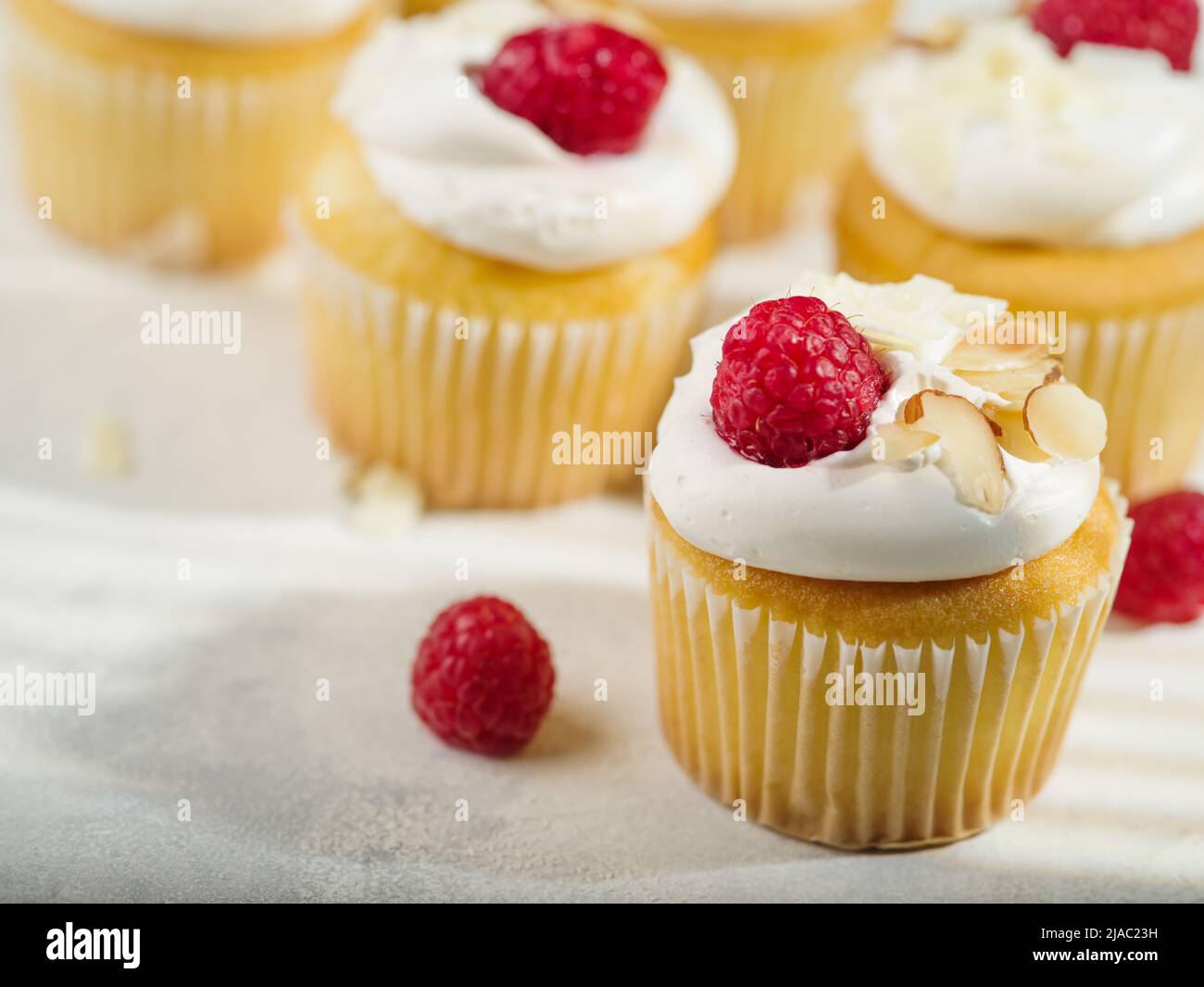 Un sacco di muffin con panna, lamponi e mandorle. Isolato su sfondo bianco. Composizione festiva. Ristorante, hotel, caffetteria, pasticceria, Foto Stock