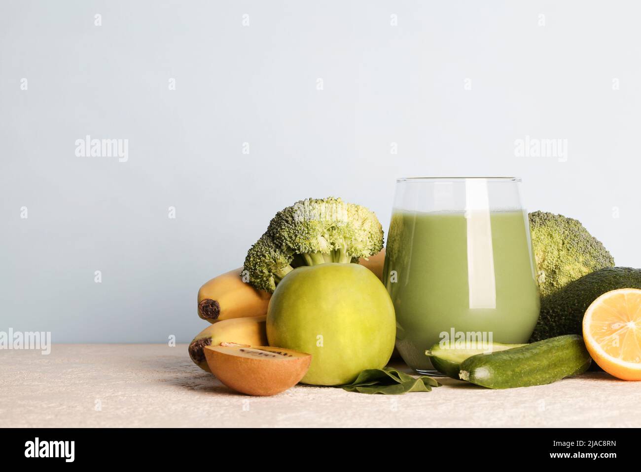 Frullato verde fresco in vetro con verdure su sfondo blu. Cibo vegano, lifestyle sano.sano detox dieta copia spazio Foto Stock